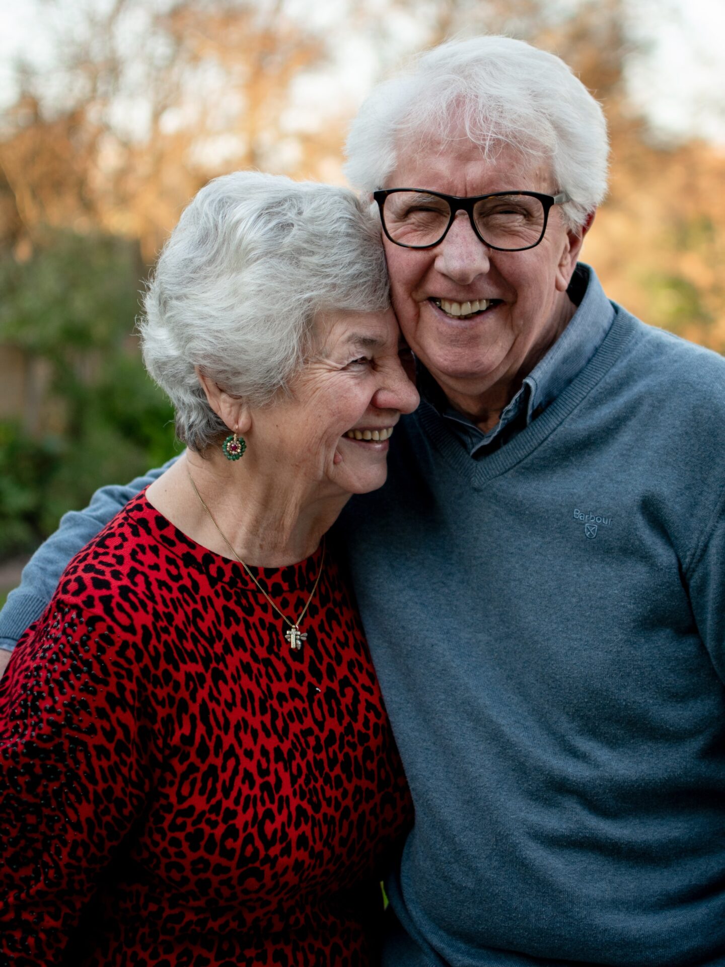 Elderly couple smiling while hugging each other